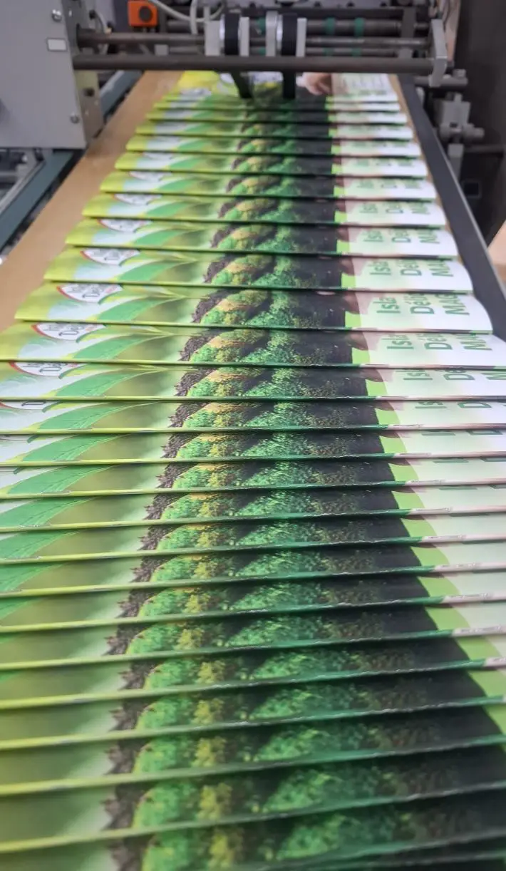 brochures agrafées vertes empilées sortant de machine